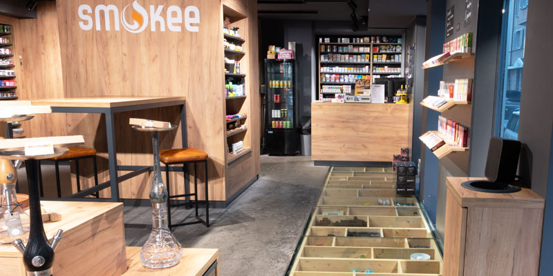Einblick in die Smokee Filiale Luzern mit Glasboden, moderner Holzgestaltung und &uuml;bersichtlicher Pr&auml;sentation der Produkte.