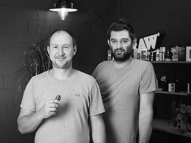 Schwarzweiss-Portrait von Ivan und Andreas, den Gründern von Smokee, die gemeinsam im Studio stehen und die familiäre, authentische Unternehmenskultur widerspiegeln.