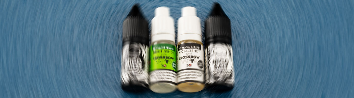 Fläschchen mit Nikotin-Shots und NicSalt-Liquids von Crossbow im Unschärfe-Effekt