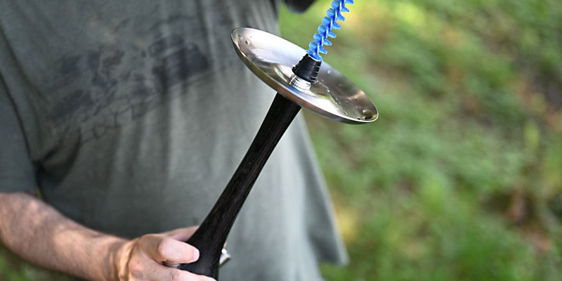 Männliche Person, die eine Reinigungsbürste durch die Shisha zieht