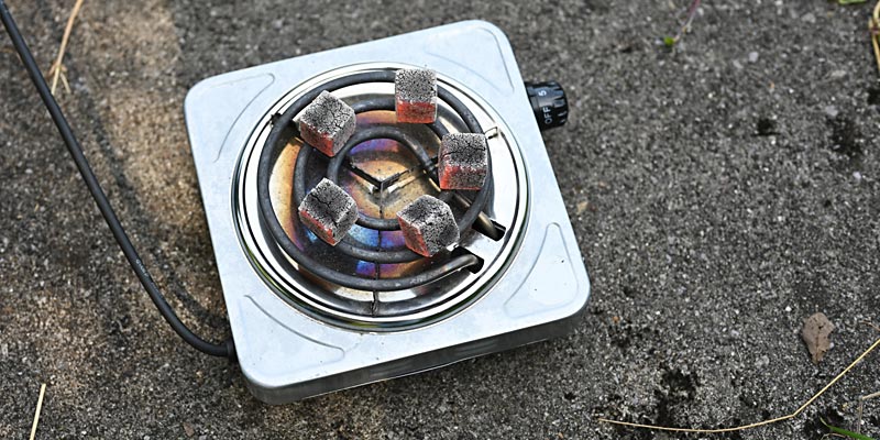 Shisha-Kohleanzünder auf steinernem Untergrund mit glühenden Shisha-Kohlen