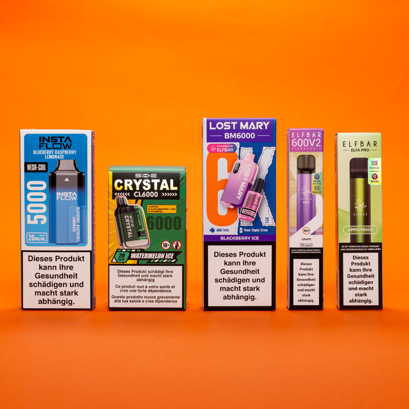 F&uuml;nf verschiedene Verpackungen von Einweg-E-Zigaretten (Disposables) der Marken Insta Flow, SKE Crystal, Lost Mary und Elfbar, aufgereiht vor einem orangefarbenen Hintergrund. Jede Packung zeigt die jeweilige Geschmacksrichtung und enth&auml;lt eine gesetzliche Gesundheitswarnung.