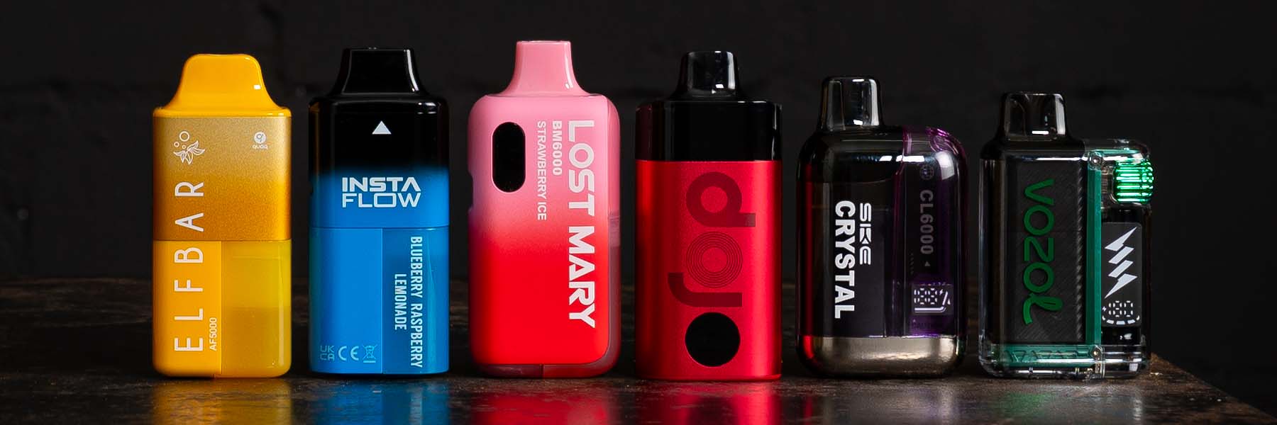 Verschiedene Vapes, Liquids und Batterien verstreut auf blauem Hintergrund.