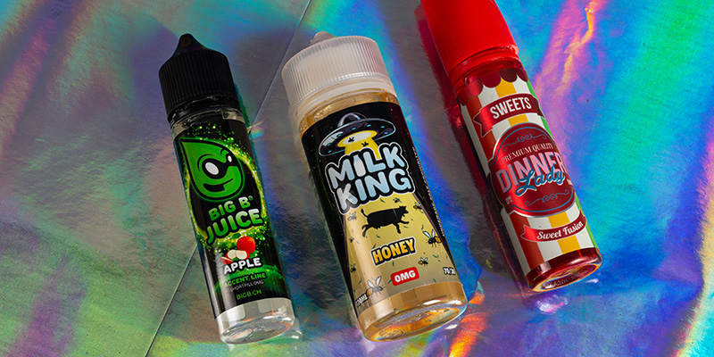 Drei bunte E-Liquid Flaschen mit den Etiketten Big B Juice Apple, Milk King Honey und Dinner Lady Sweets
