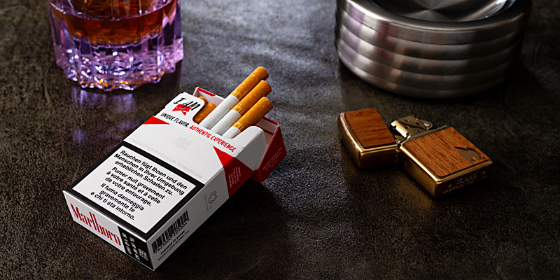 Offene Marlboro-Zigarettenpackung mit Zigarette, Feuerzeug und Aschenbecher – beliebte Zigarettenmarken bei Smokee.ch