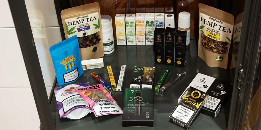 Auslage mit CBD-Produkten, Hanftee, CBD-Vapes, Tropfen und Joints in der Smokee-Filiale Aarau. Vielfältige Auswahl an natürlichen CBD- und Hanfprodukten.