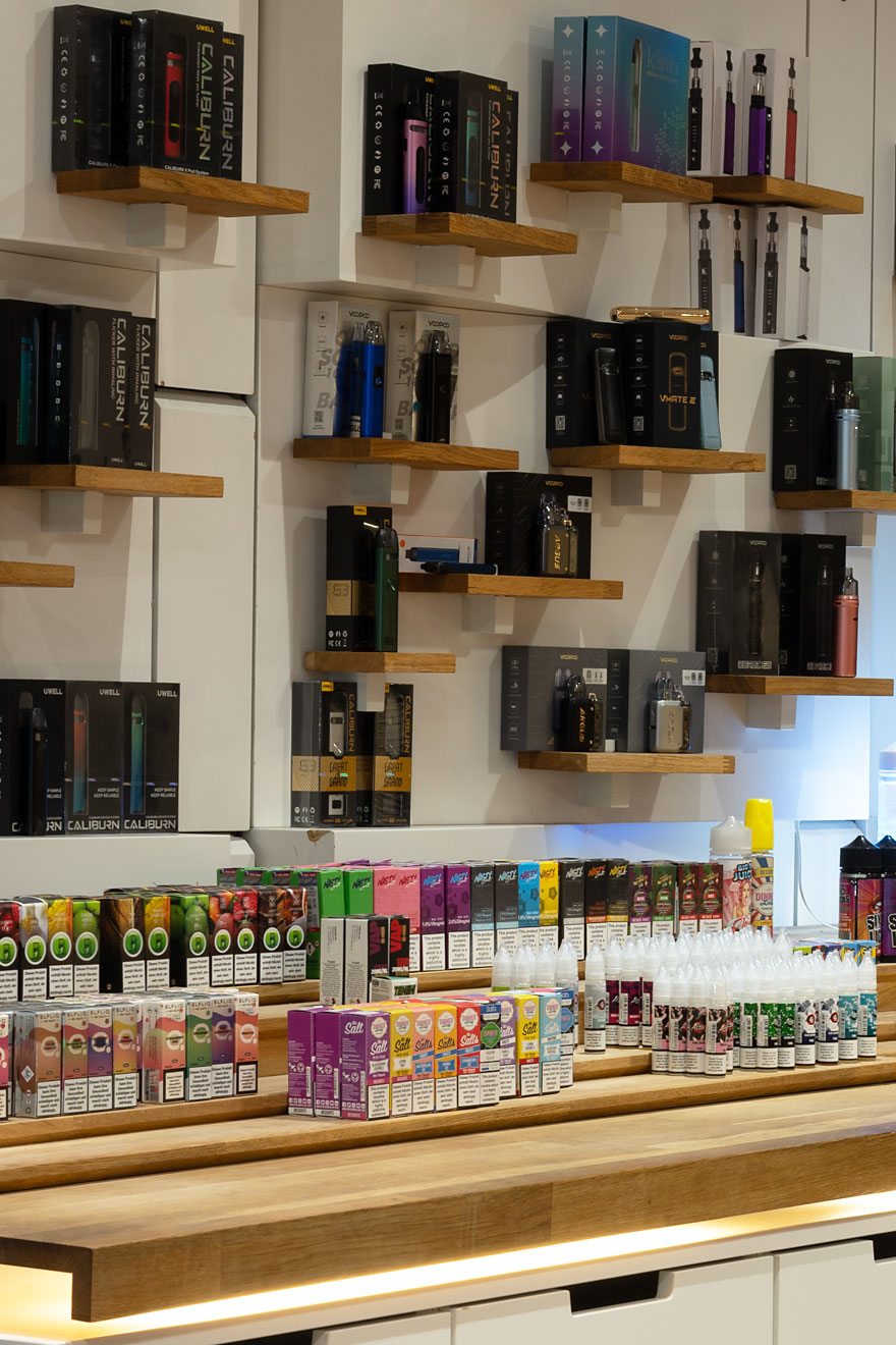 Verschiedene E-Zigaretten, Vapes und Liquids ausgestellt in Regalen bei Smokee Aarau.