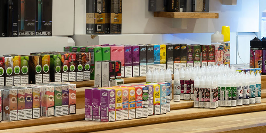 Verschiedene E-Zigaretten, Vapes und Liquids ausgestellt in Regalen bei Smokee Aarau.