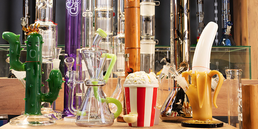 Buntes Bong-Sortiment im Headshop-Bereich von Smokee Baden – kreative Designs wie Kaktus, Popcorn und Banane aus Glas.