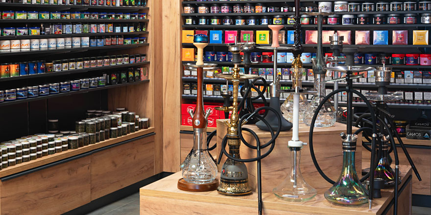 Innenansicht des Smokee-Shops in Baden mit einer Auswahl an hochwertigen Shishas und Regalen voller Tabakdosen in verschiedenen Farben und Marken.