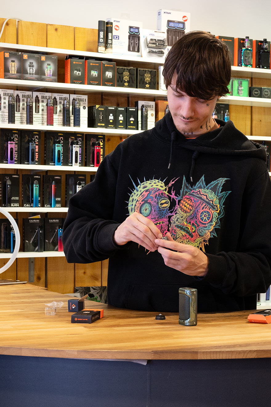 Porträt eines jungen Mannes mit Gesichtstattoos, Piercings und Kapuzenpullover – Mitarbeiter Marc von Smokee