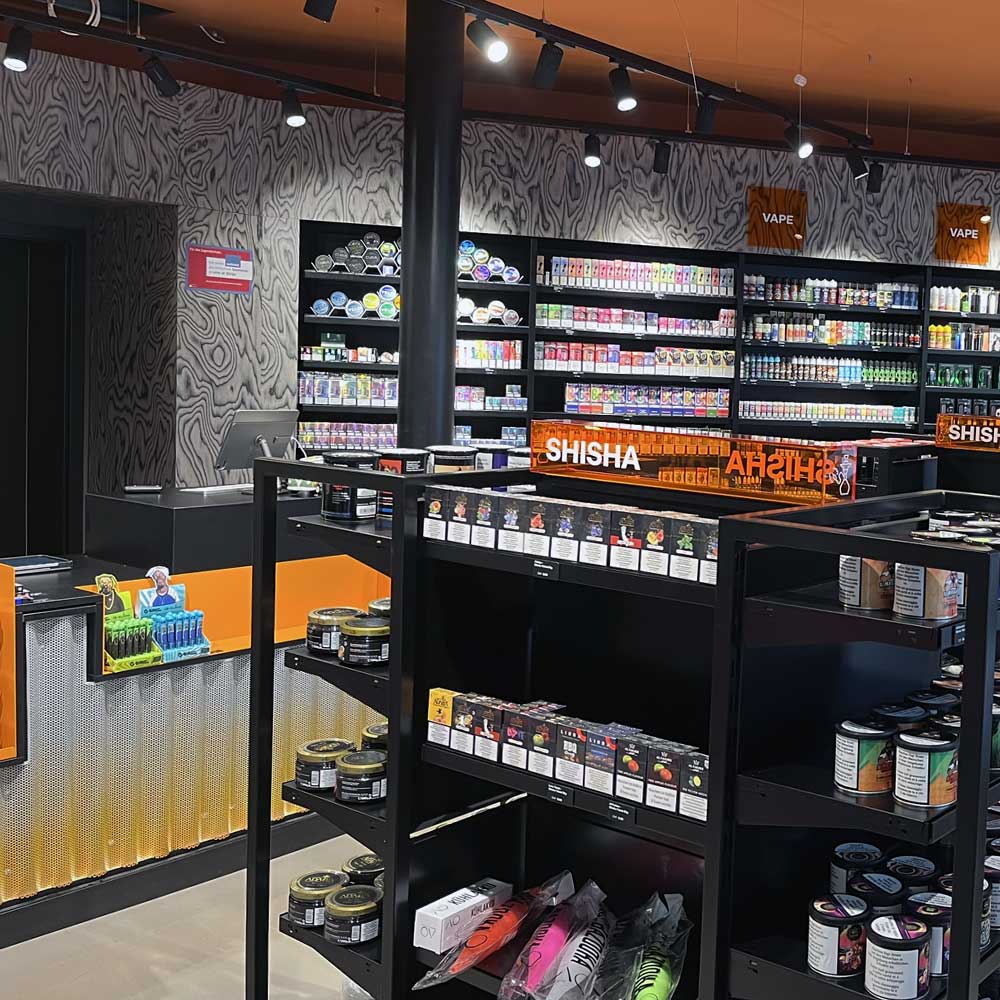 Kassenbereich der Smokee-Headshop-Abteilung mit Zigaretten und Vapes im Hintergrund.