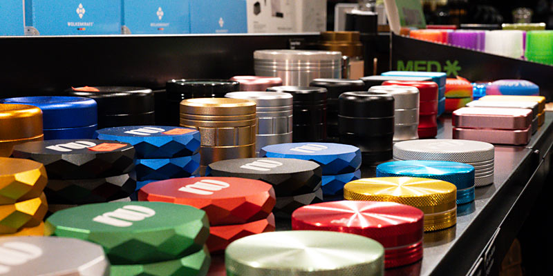 Verschiedene bunte Metall-Grinder in einem Headshop-Regal in der Schweiz