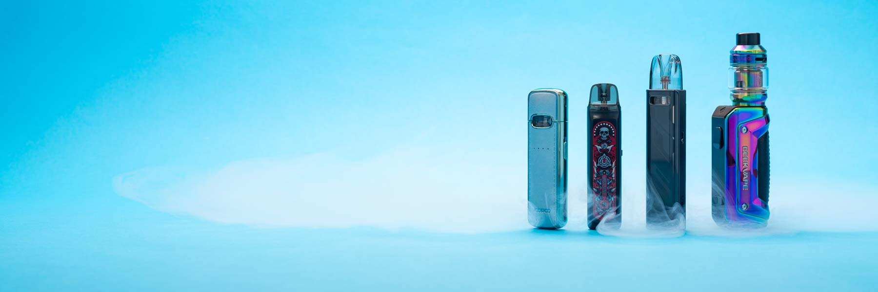 Verschiedene Vapes, Liquids und Batterien verstreut auf blauem Hintergrund.